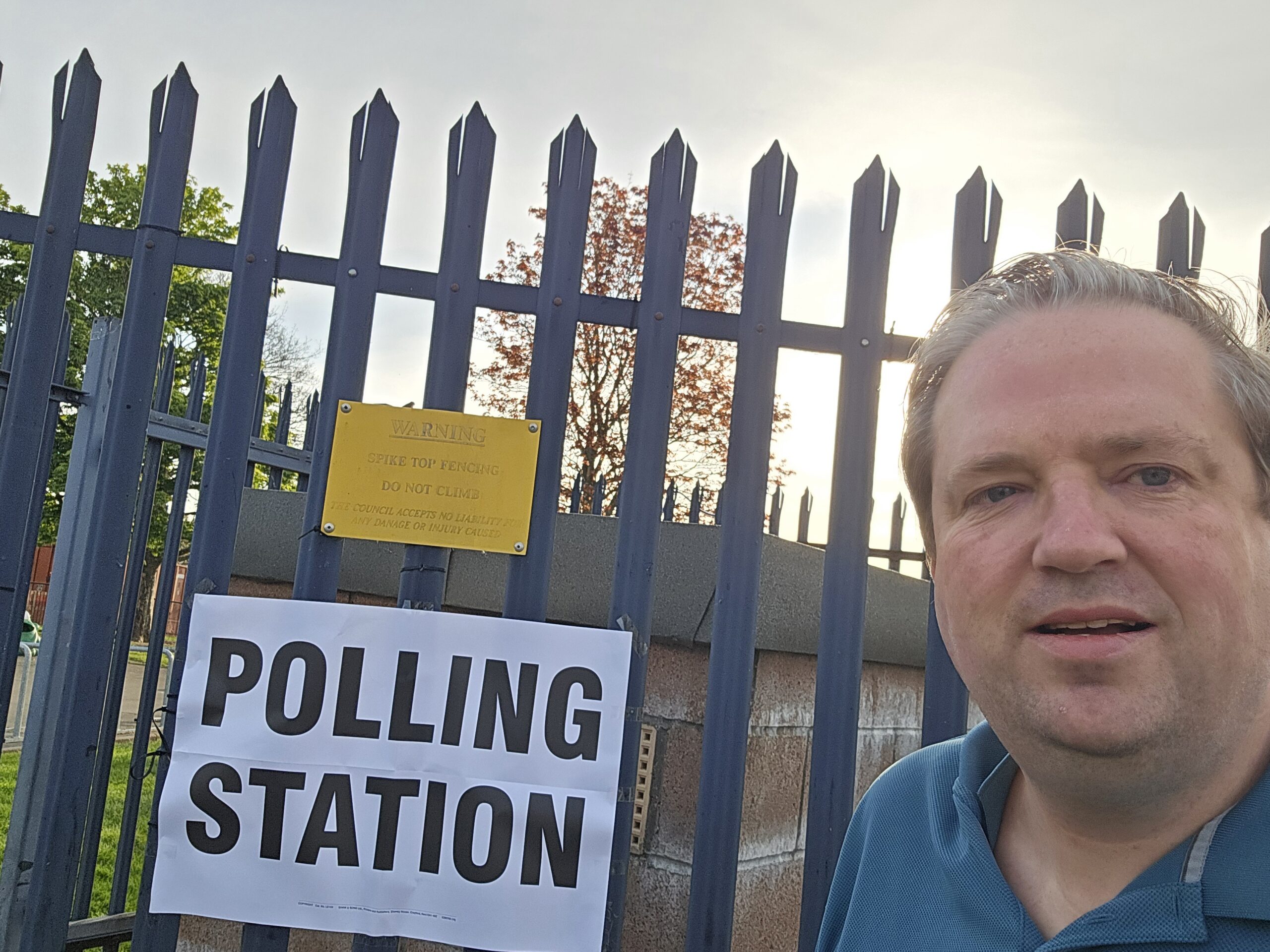 Polling station building with party campaign boards outside