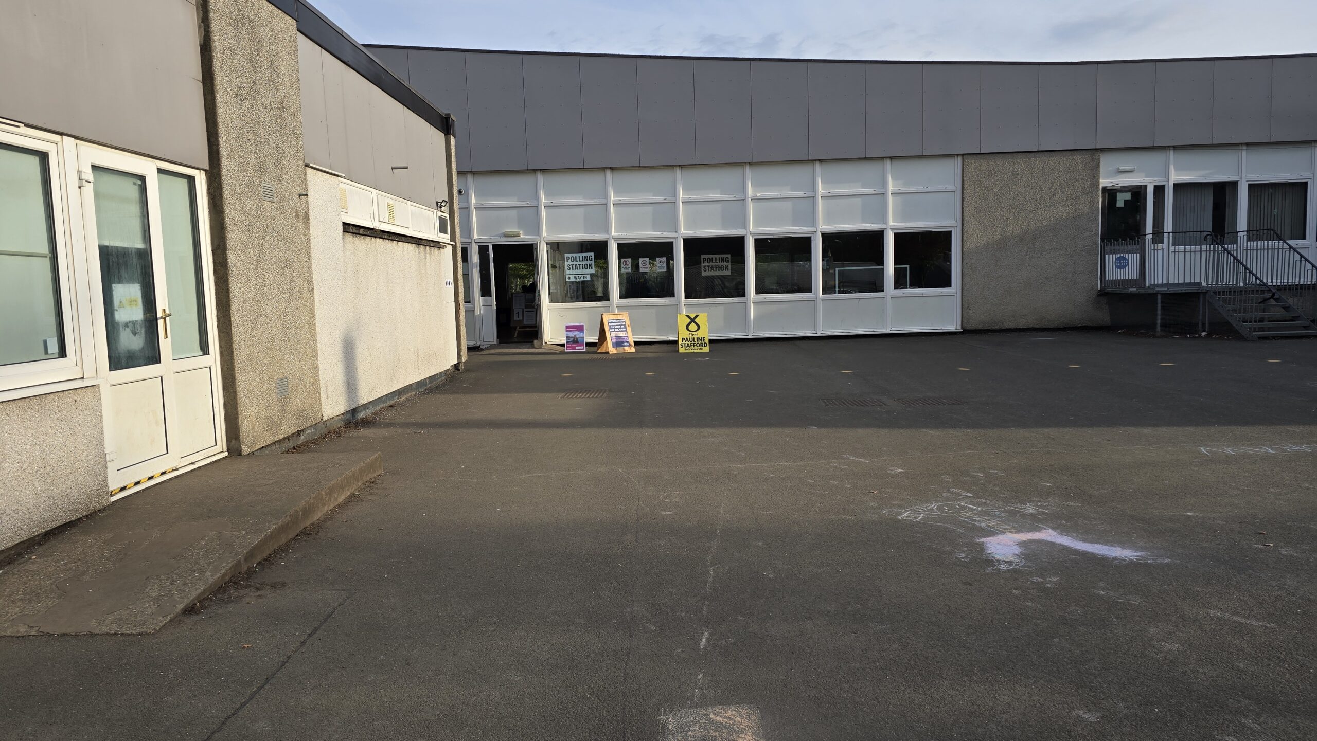 Polling station building with party signs outside